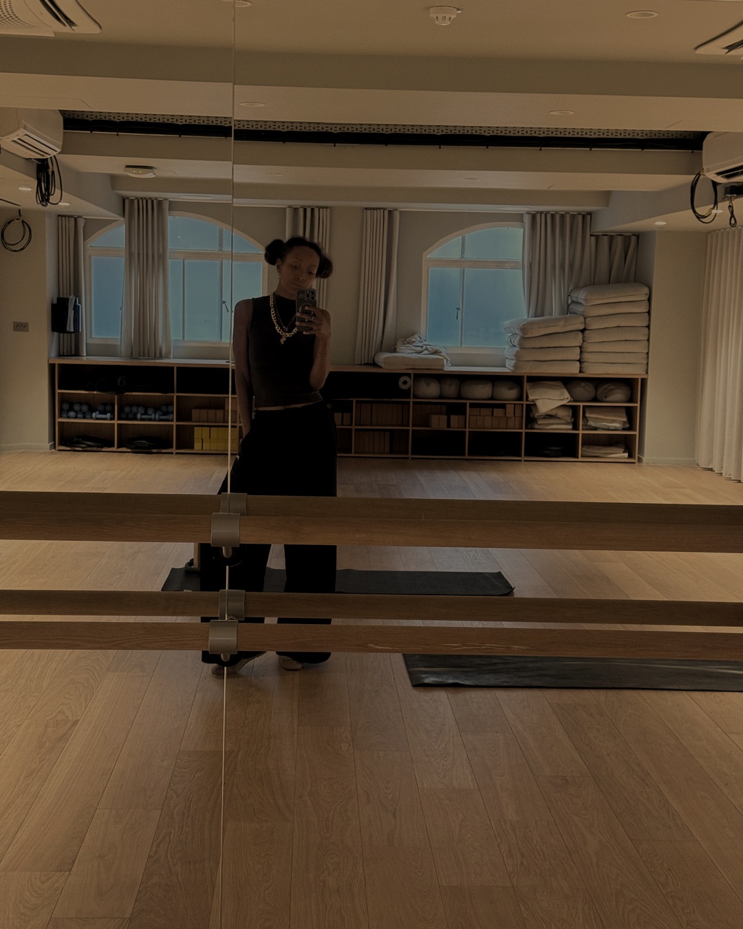 Latesha in a calm, warm studio with wooden floors and barres