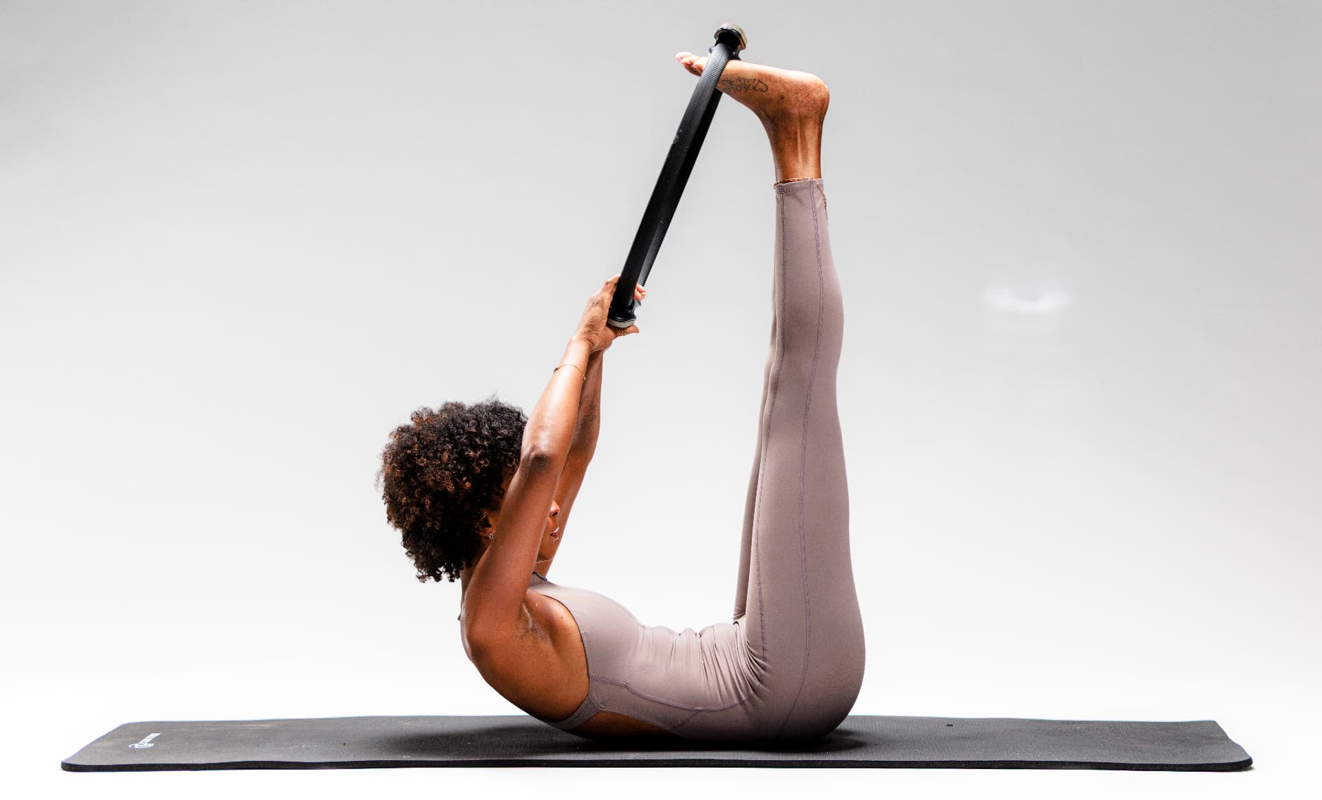 Latesha lifting a Pilates ring during classical mat work