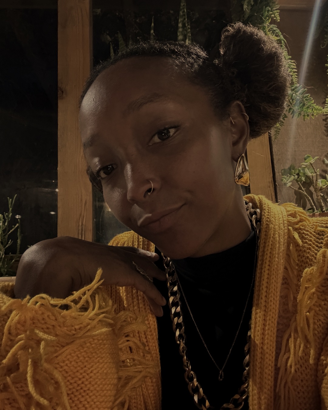 Latesha resting in a warm knitted cardigan