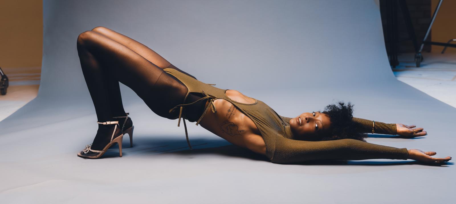 Wide editorial studio portrait, reclined bridge across the frame